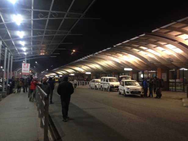 Outside the Tribhuvan International Airport. To the right, taxis. To the left, drivers. Missing: my driver.